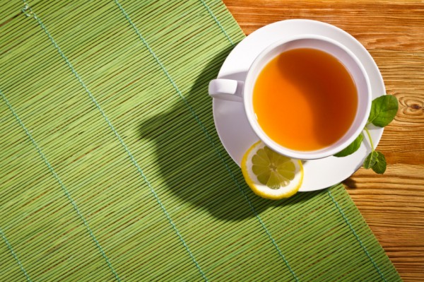 Hot tea with fresh leves and lemon on bamboo mat