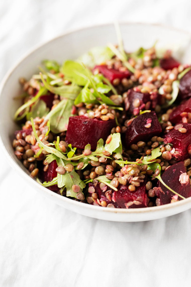 A vibrant, colorful bowl of a vegan lentil beet salad.