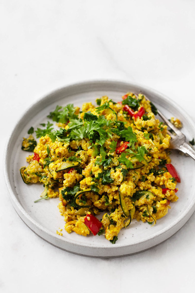 An angled photograph of a vegan breakfast plate of tofu vegetable quinoa scramble.