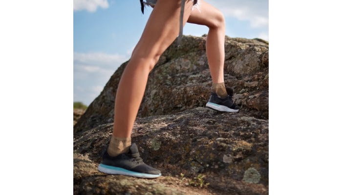 Person hiking up mountain wearing foot sleeves.