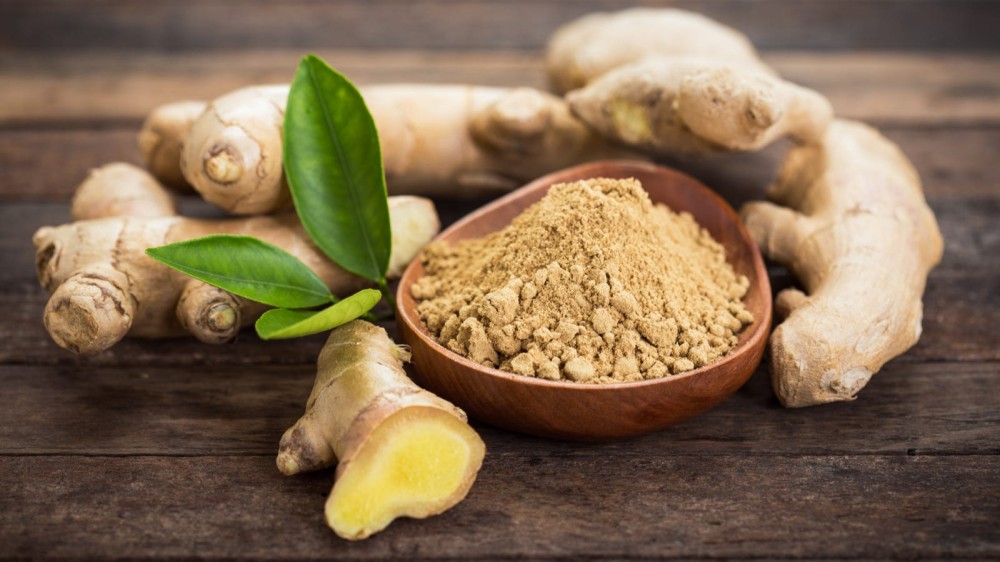 Ginger root with a small bowl ground ginger.