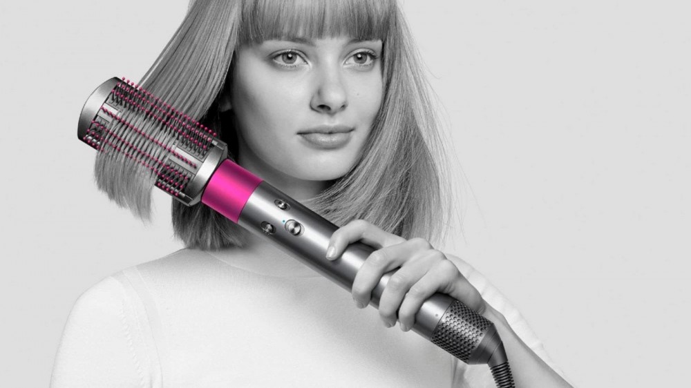 A woman styling her hair with the Dyson Airwrap.