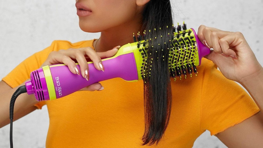 A woman using the One-Step Hair Dryer and Volumizer Hot Air Brush.