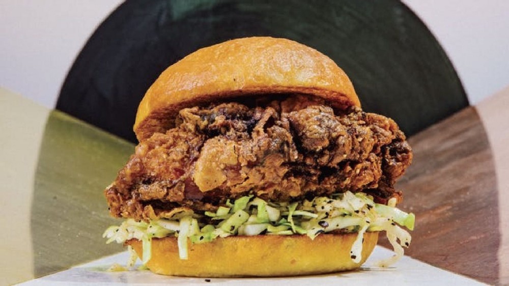 An image of deep fried pickled brined chicken sandwich with a pepper slaw on a warm grilled bun.