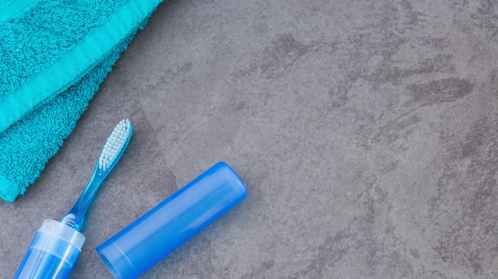 Blue boothbrush with plastic box.